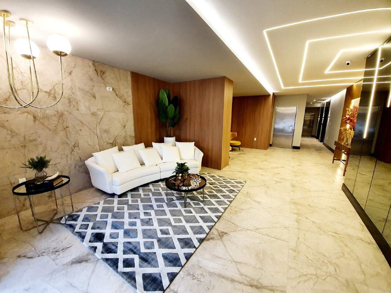 Hall de entrada com sofá e piso em mármore