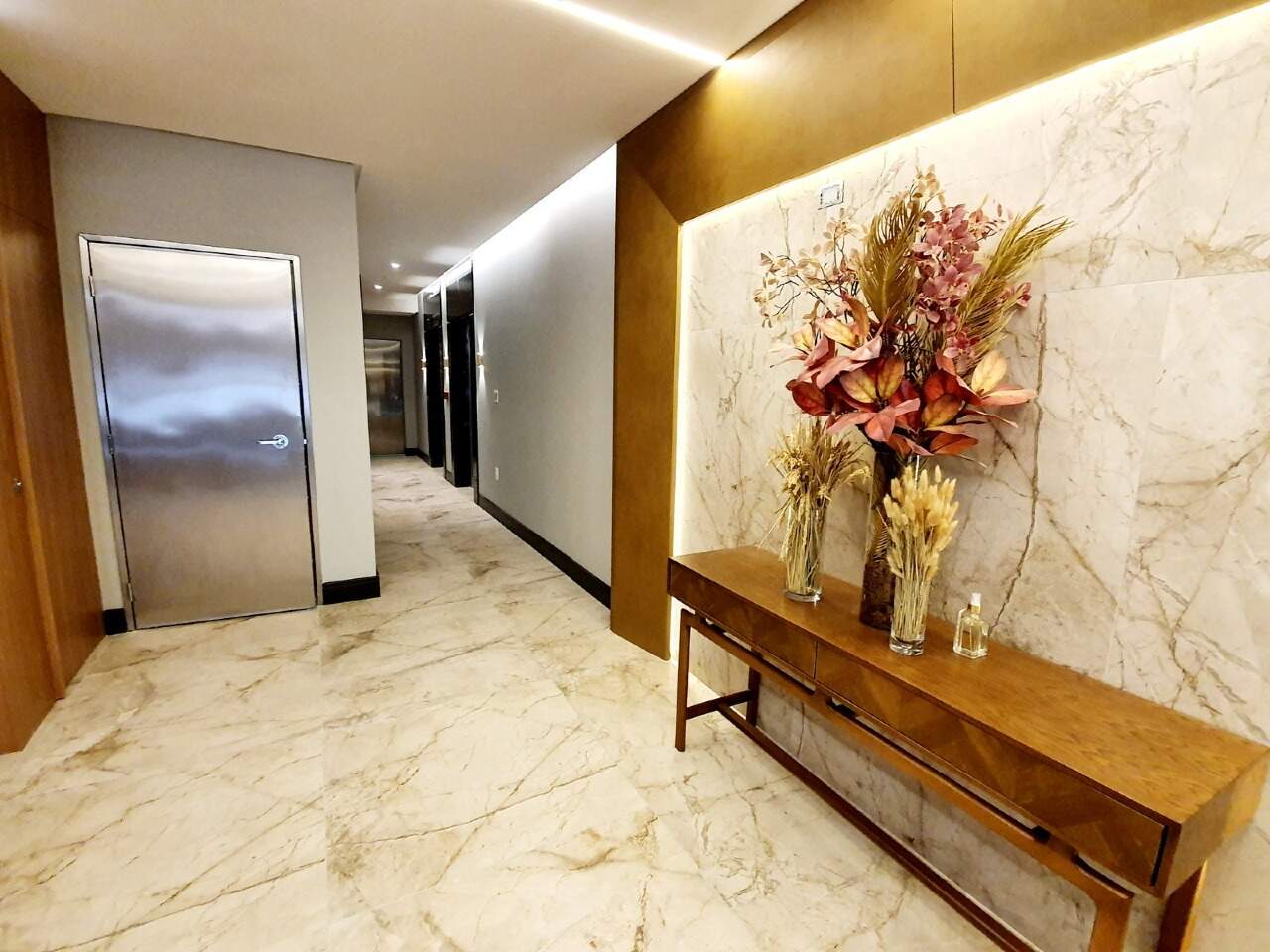 Circulação do hall com aparador e arranjo de flores