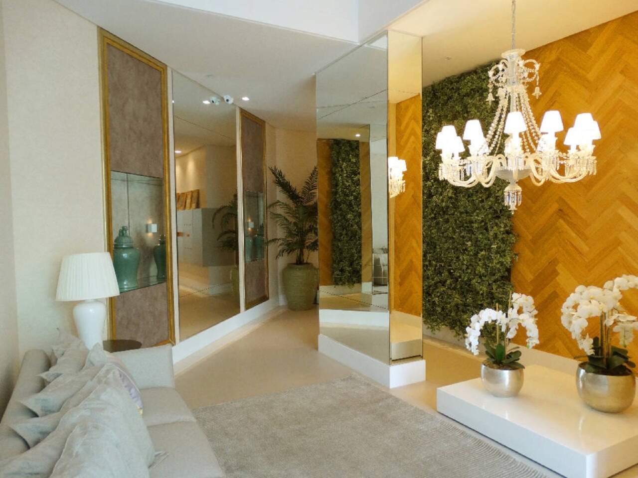 Hall de entrada com lustre, painel de madeira e jardim vertical