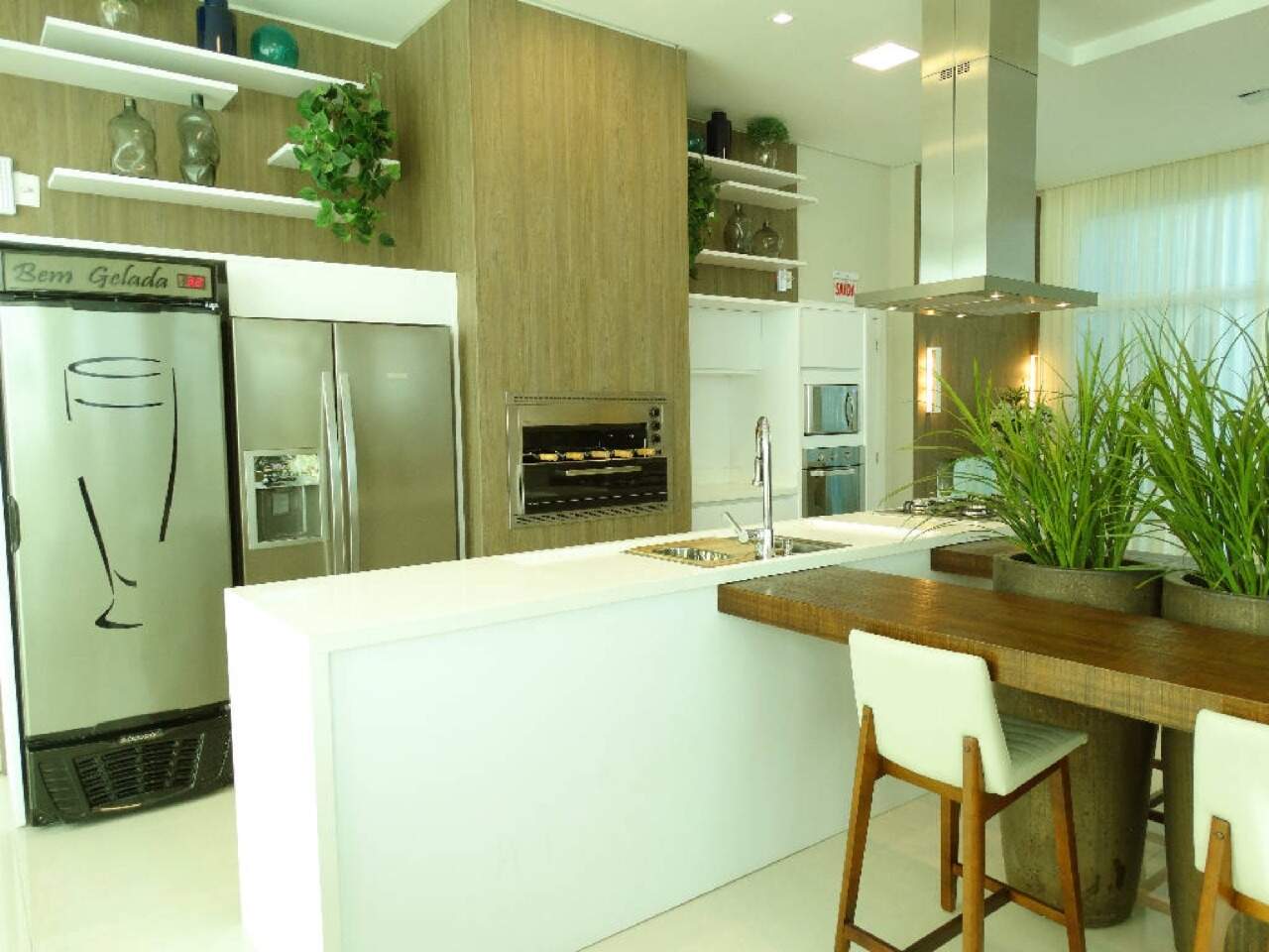 Espaço gourmet com churrasqueira, bancada e cervejeira