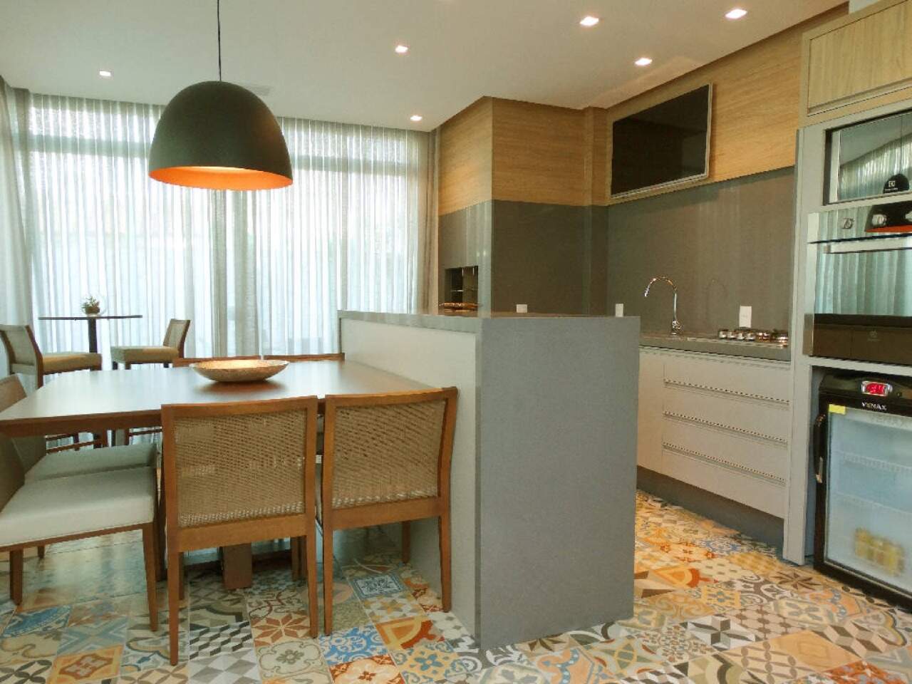 Espaço gourmet com piso de ladrilho e mesa