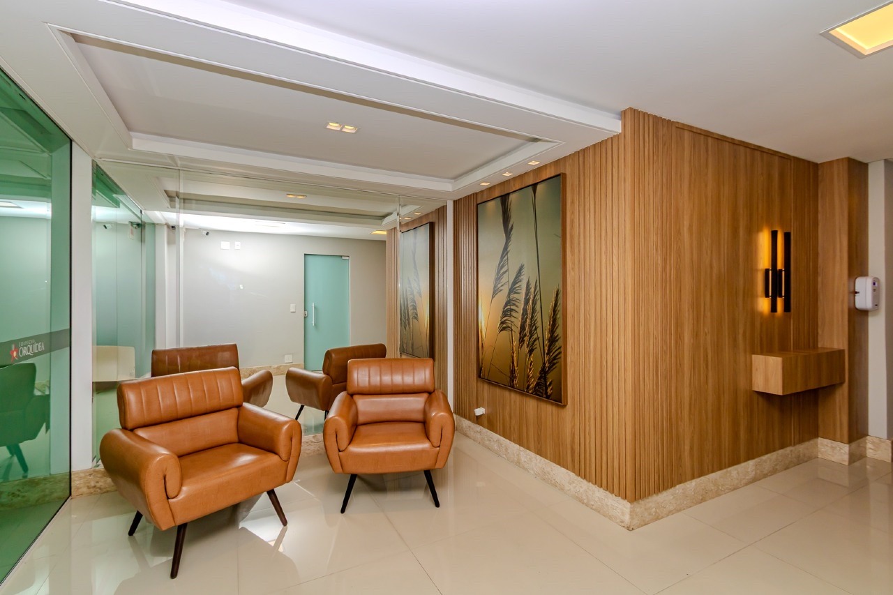 Hall de entrada com poltronas e painel de madeira