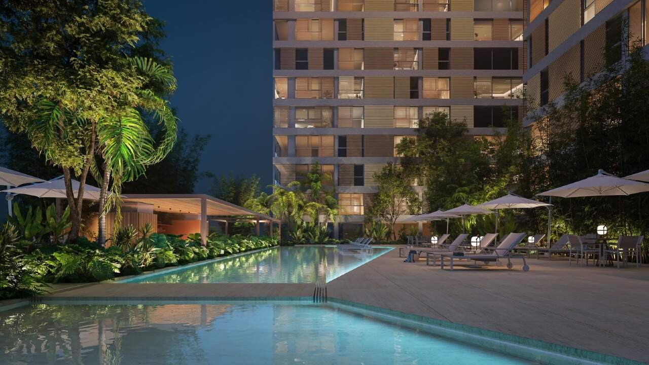 Piscina iluminada à noite, com as torres ao fundo (imagem ilustrativa)