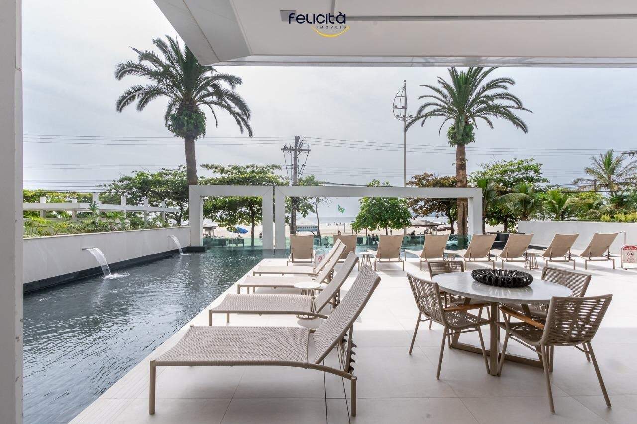 Piscina frontal com lâmina d’água e mesas no deck