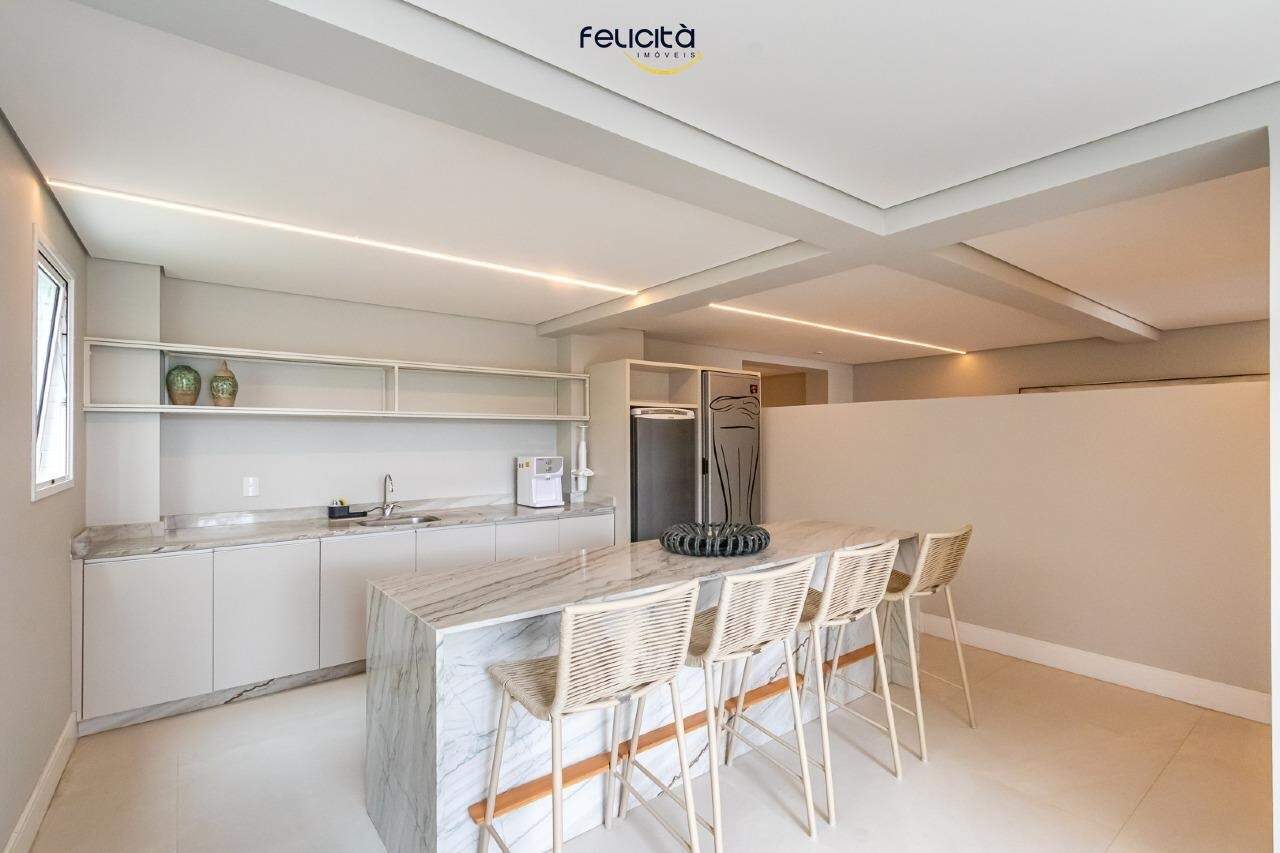 Espaço gourmet com bancada em ilha e banquetas