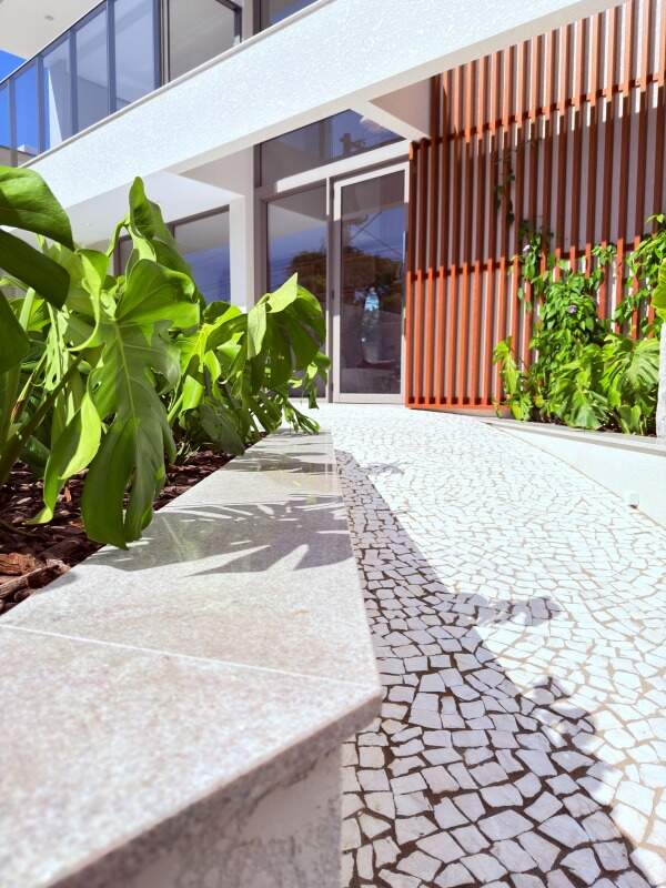 Acesso de pedestres com pedra portuguesa e jardim