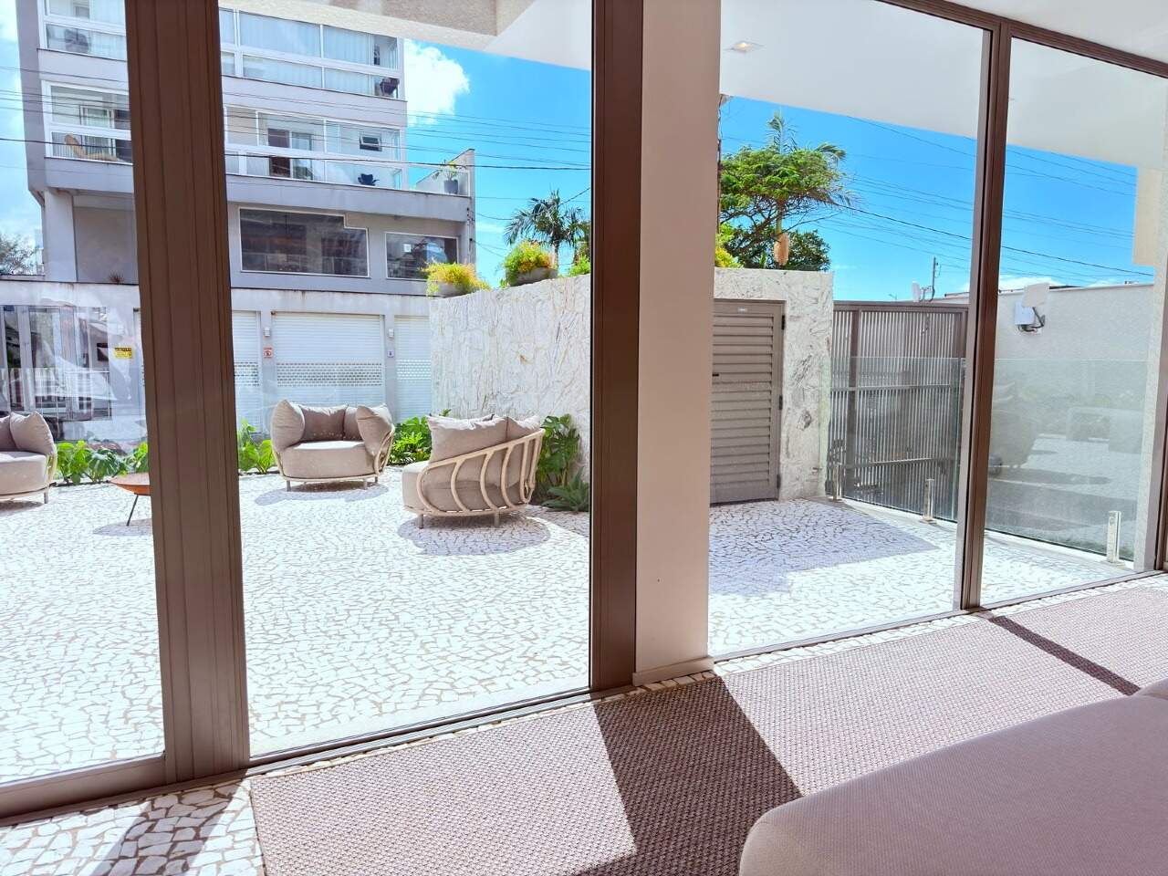 Hall de entrada com portas de vidro para o pátio