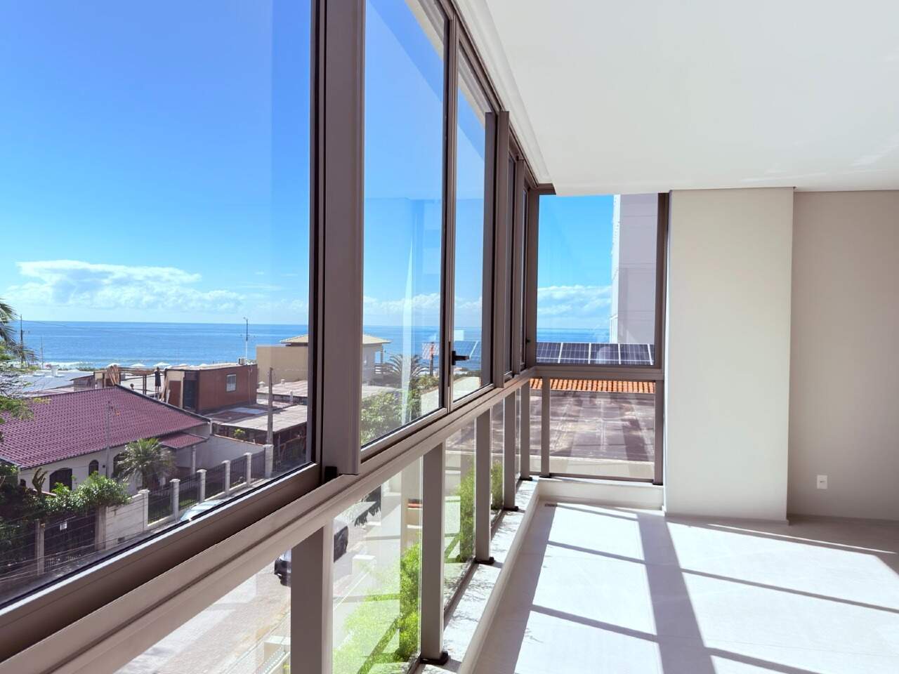 Canto envidraçado com vista para o mar por cima das casas da quadra