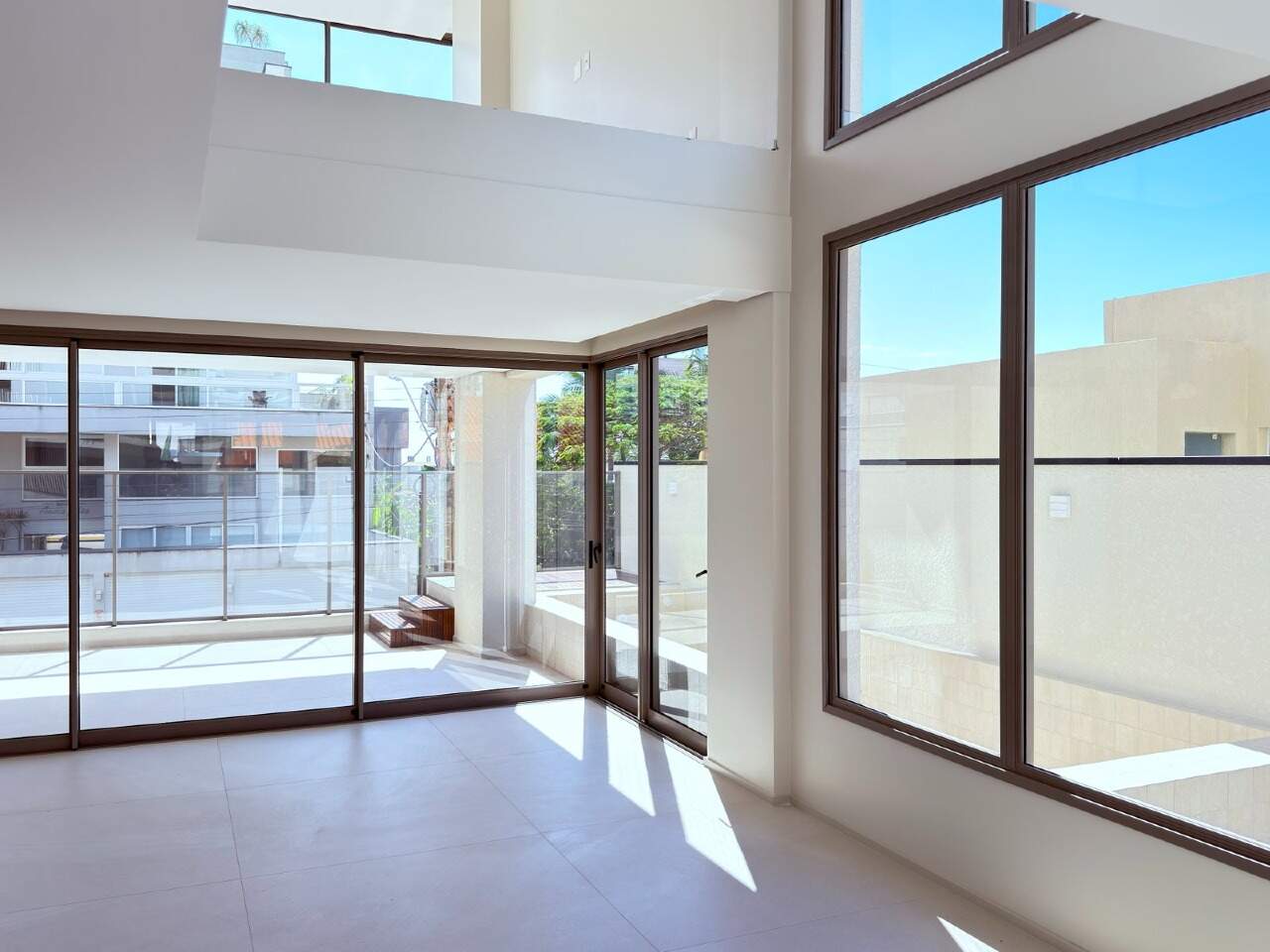 Living com pé-direito duplo em apartamento do In Exclusive Home