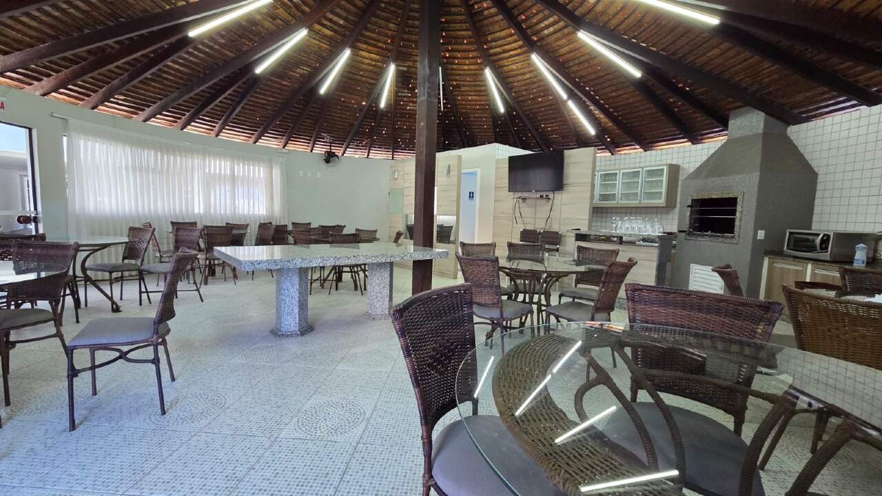 Salão de festas com mesas e teto de madeira