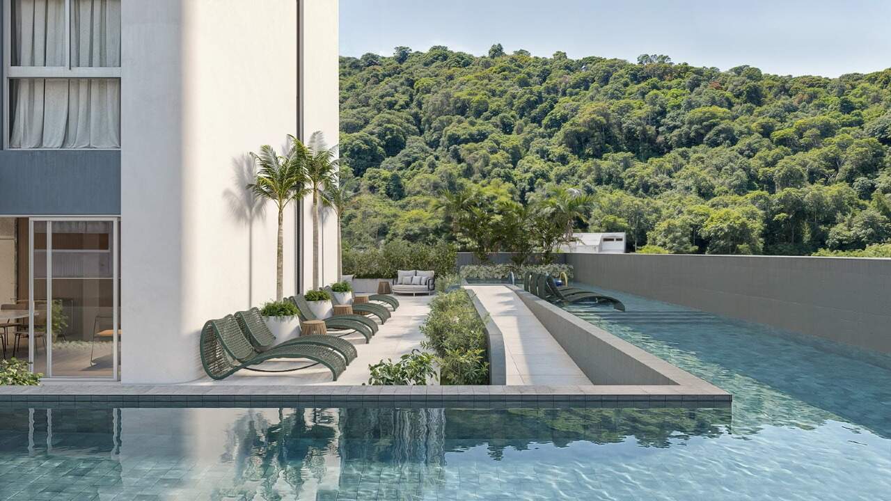 Piscina com raia e espreguiçadeiras, com o morro verde ao fundo (imagem ilustrativa)