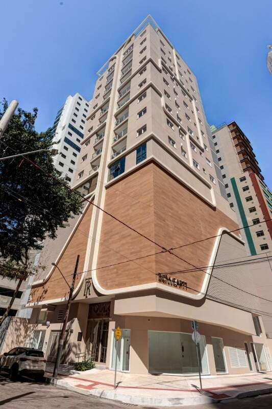 Fachada do Toulon Residence pronto, com o embasamento curvo revestido em madeira