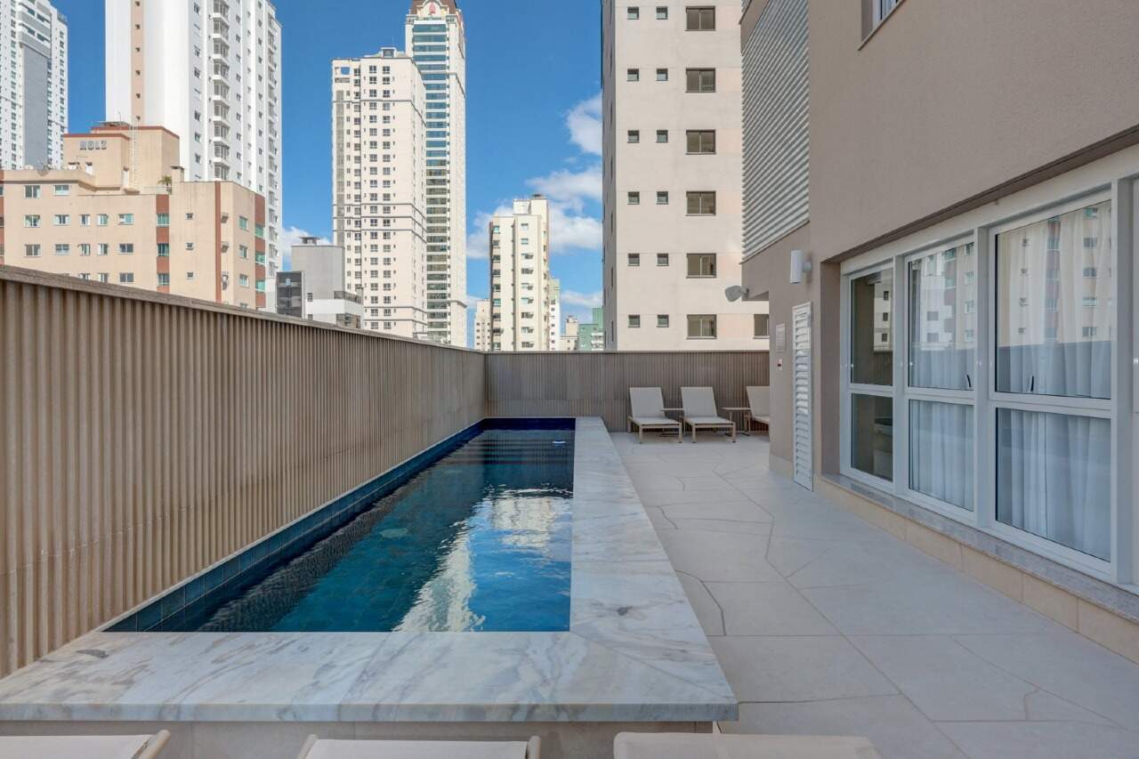 Piscina com raia e deck de pedra no lazer do Toulon Residence