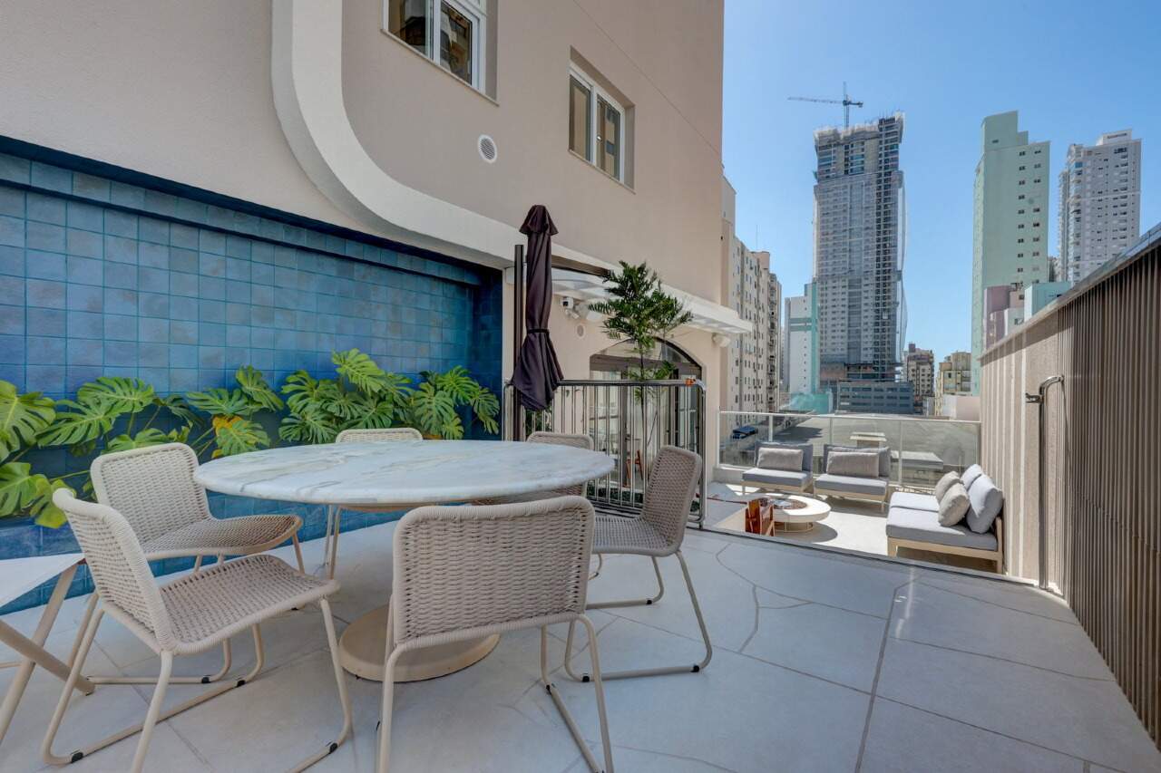 Terraço externo com mesa redonda e vista da cidade