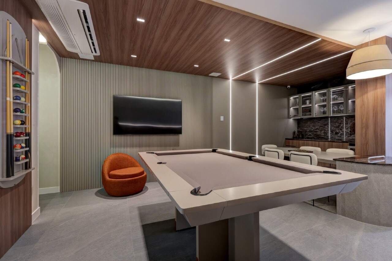 Sala de jogos com mesa de sinuca e TV