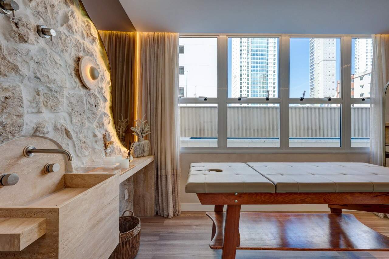Sala de massagem com parede de pedra e janela ampla