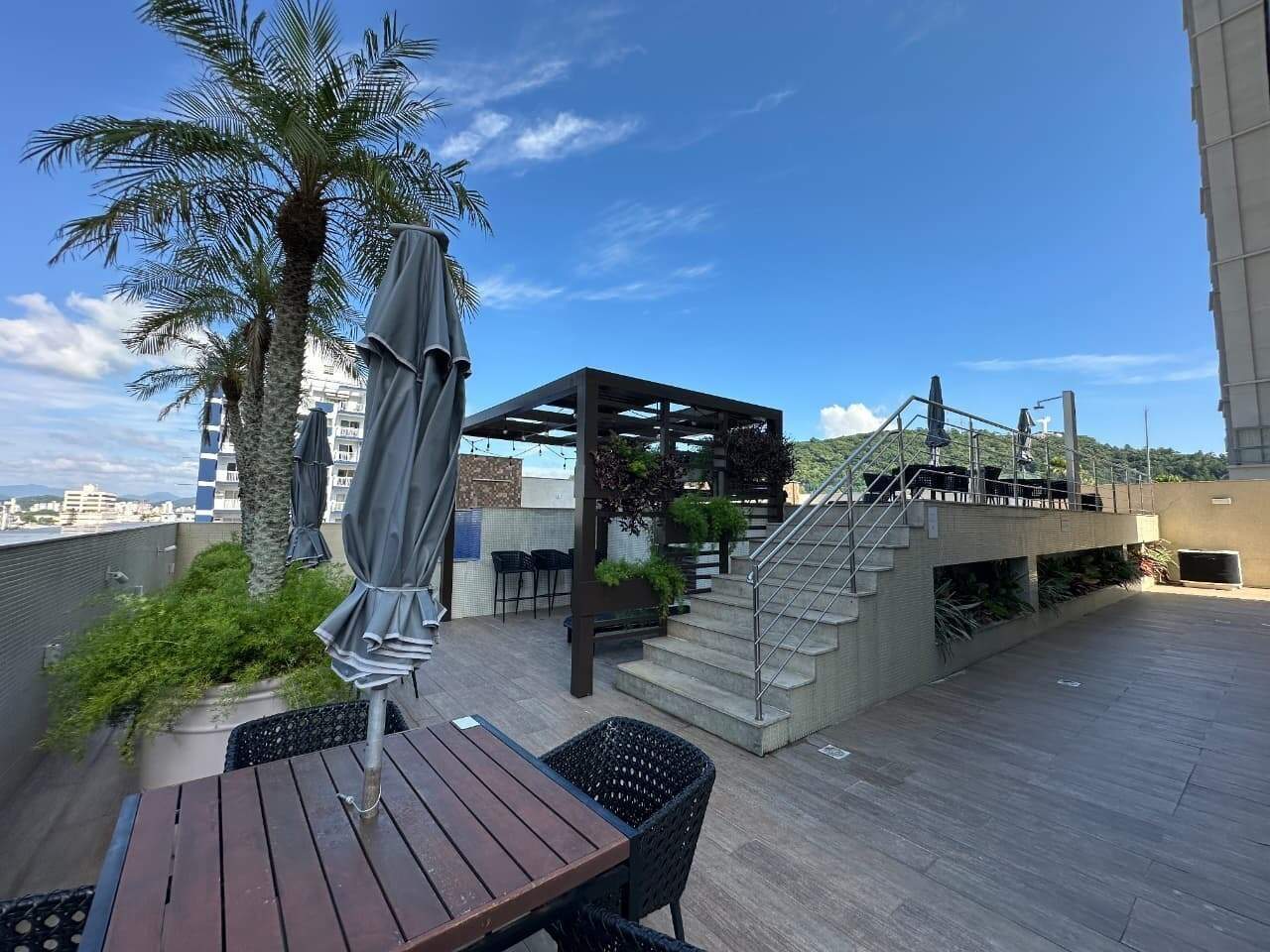 Deck com pergolado, balcão e escada para o piso superior do lazer