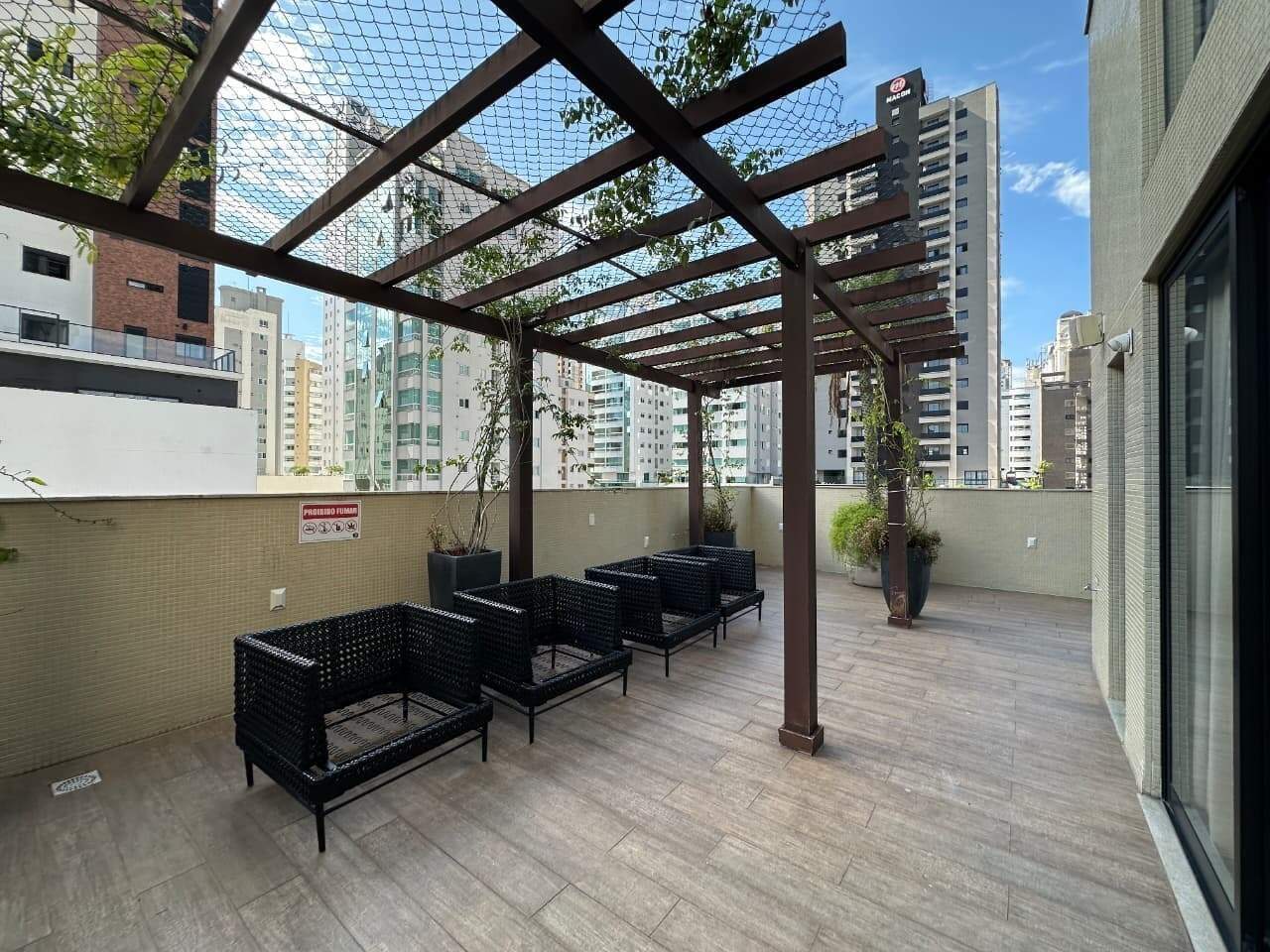 Lounge com poltronas sob o pergolado