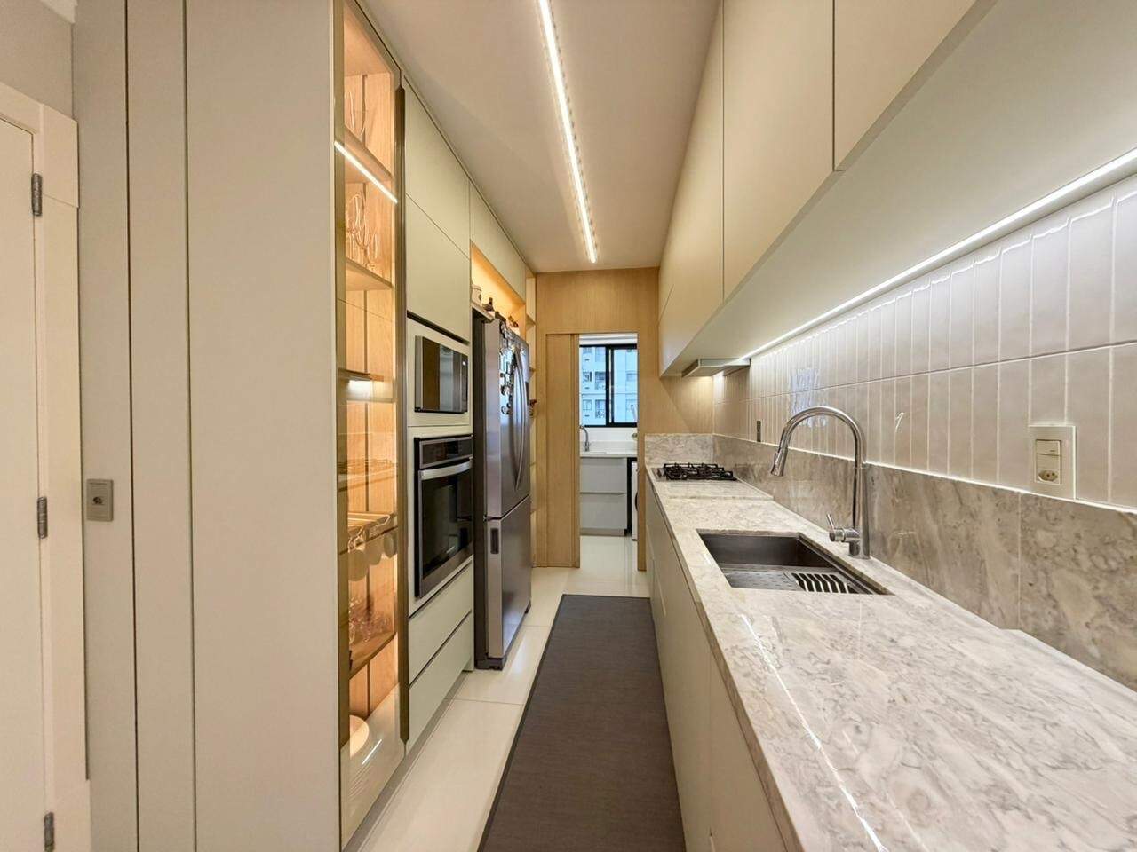 Cozinha em corredor com armários planejados, em apartamento de 127 m²