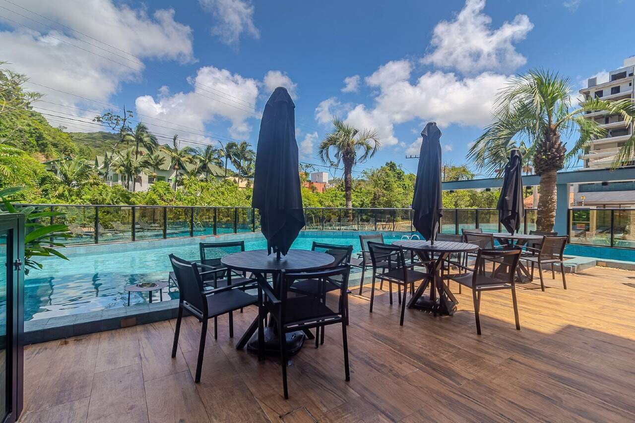 Mesas com ombrelones à beira da piscina