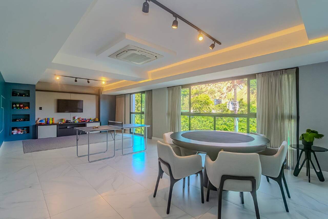 Sala de jogos com mesa de carteado e TV