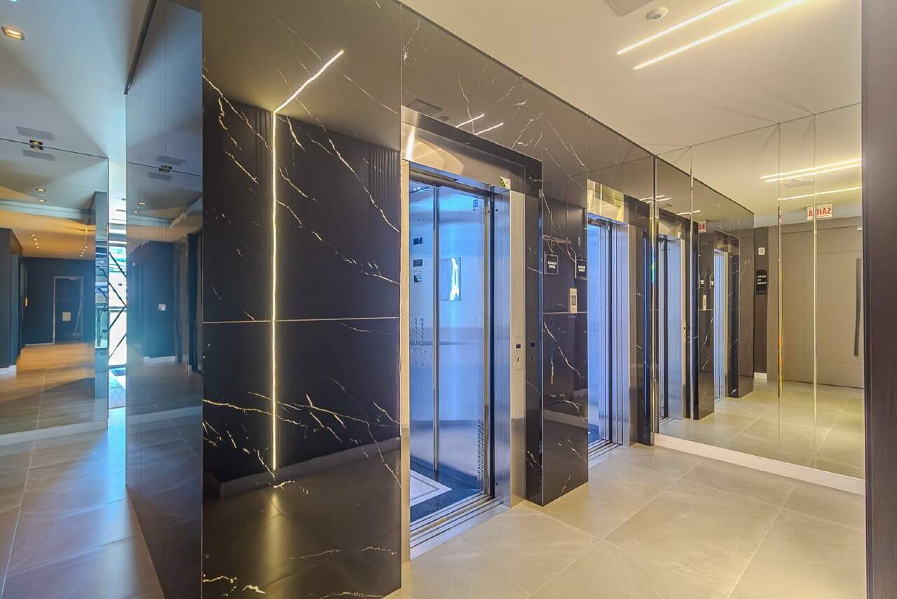 Hall dos elevadores revestido em pedra escura