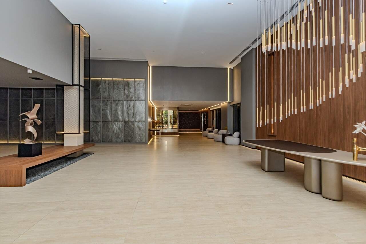 Hall de entrada do Sirena, com painel de madeira e luminárias pendentes
