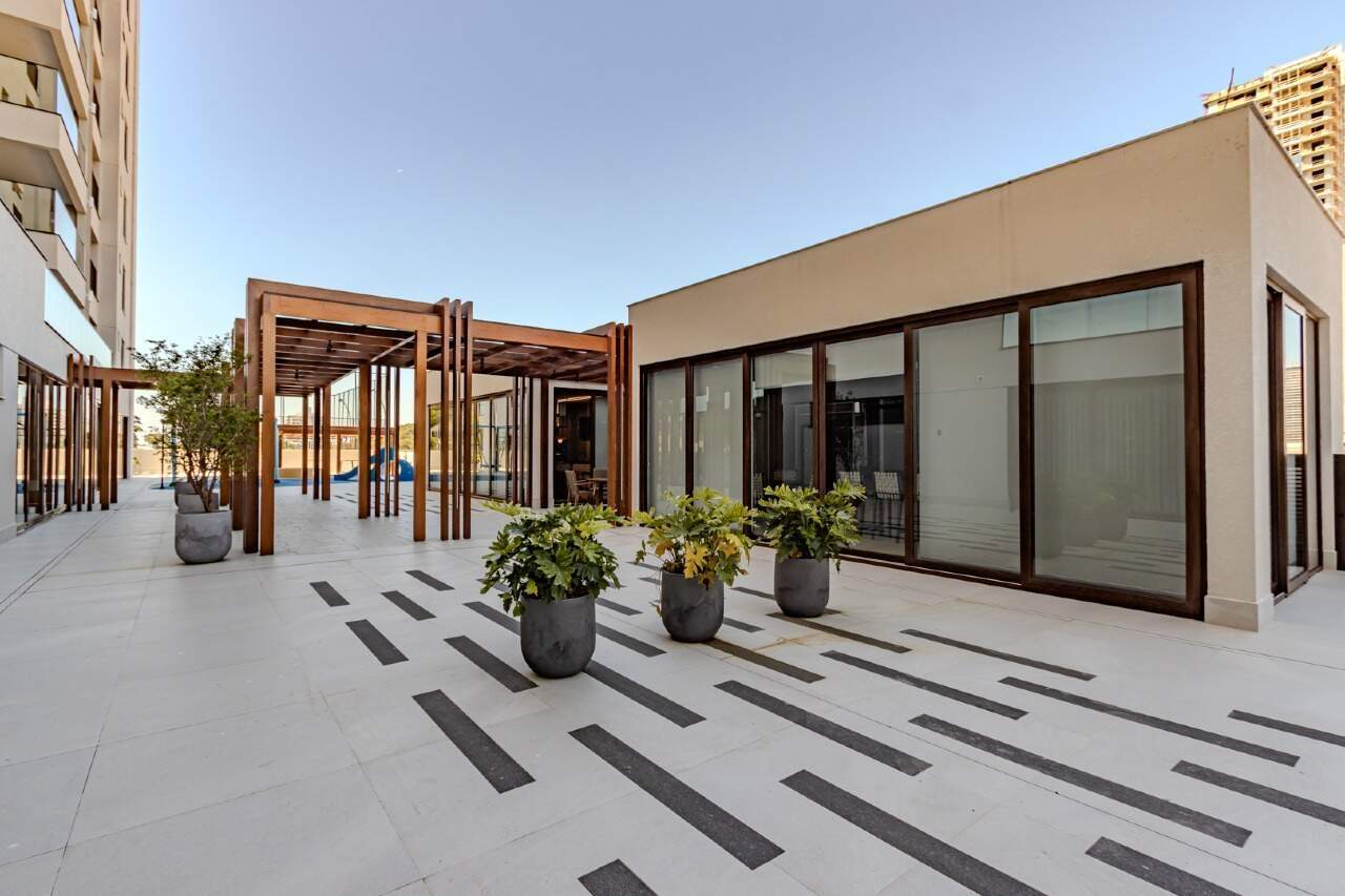 Terraço do lazer com salão envidraçado e pergolado de madeira