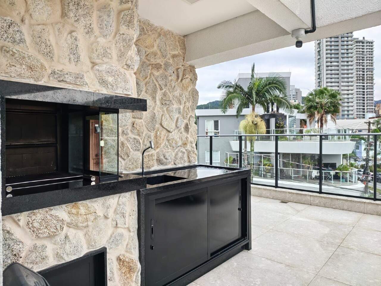 Espaço gourmet com churrasqueira a carvão no terraço