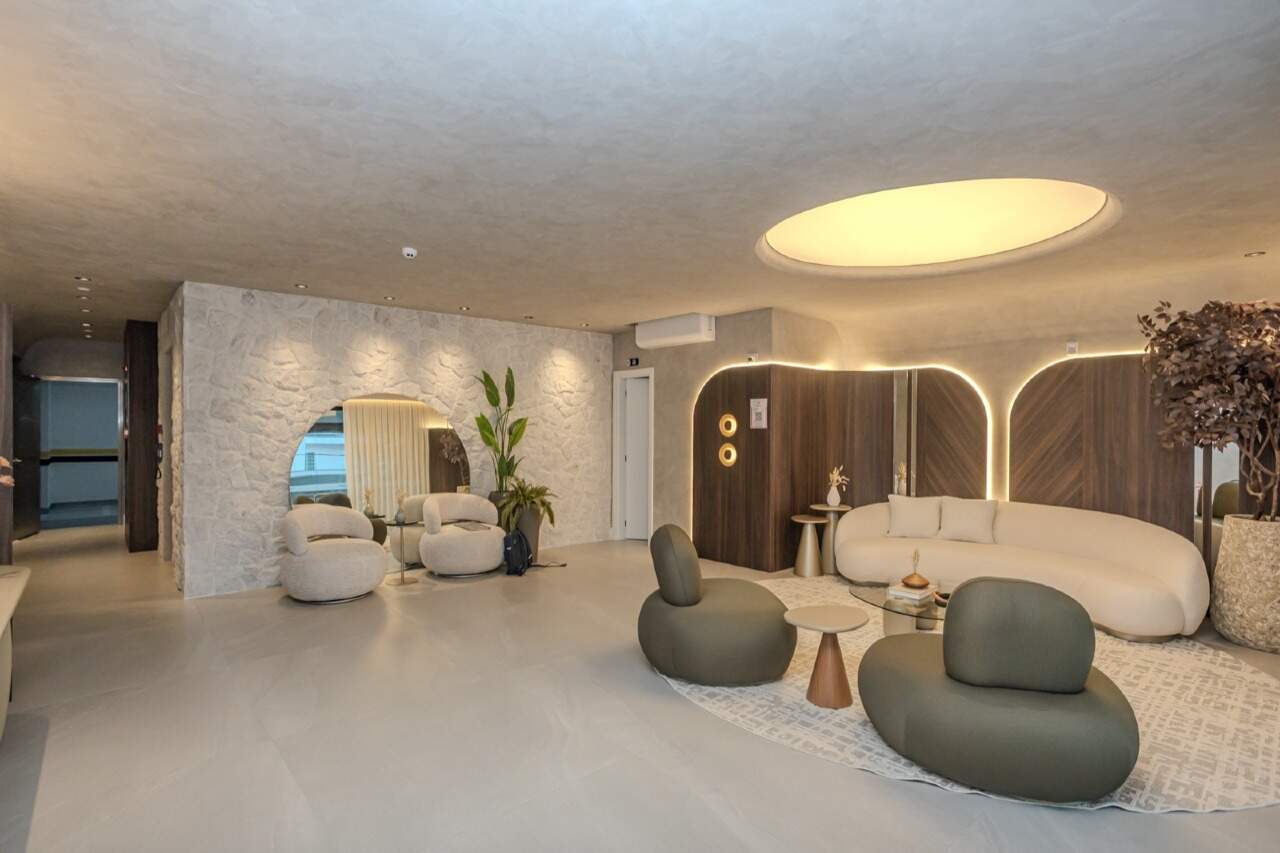 Hall de entrada decorado e mobiliado, com sofás e iluminação no teto