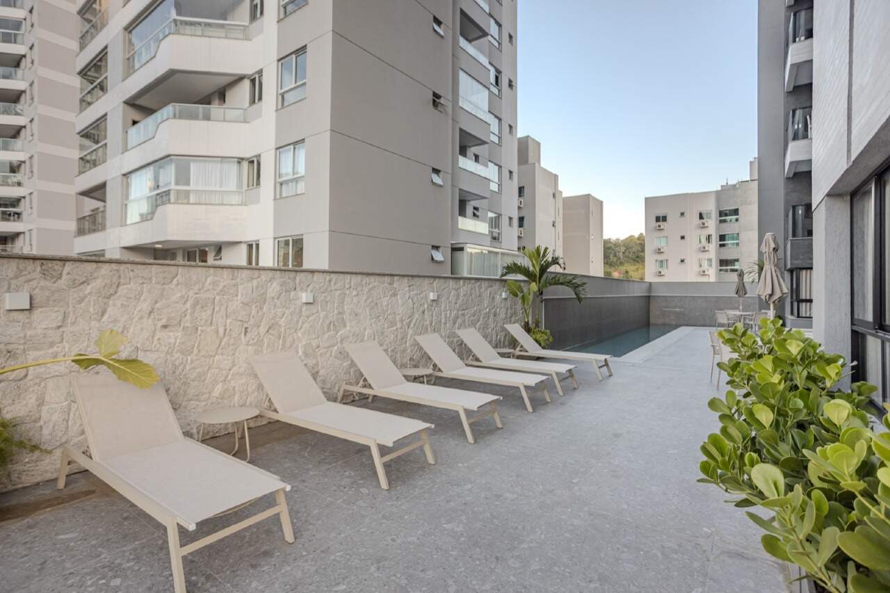 Deck com espreguiçadeiras ao lado da piscina