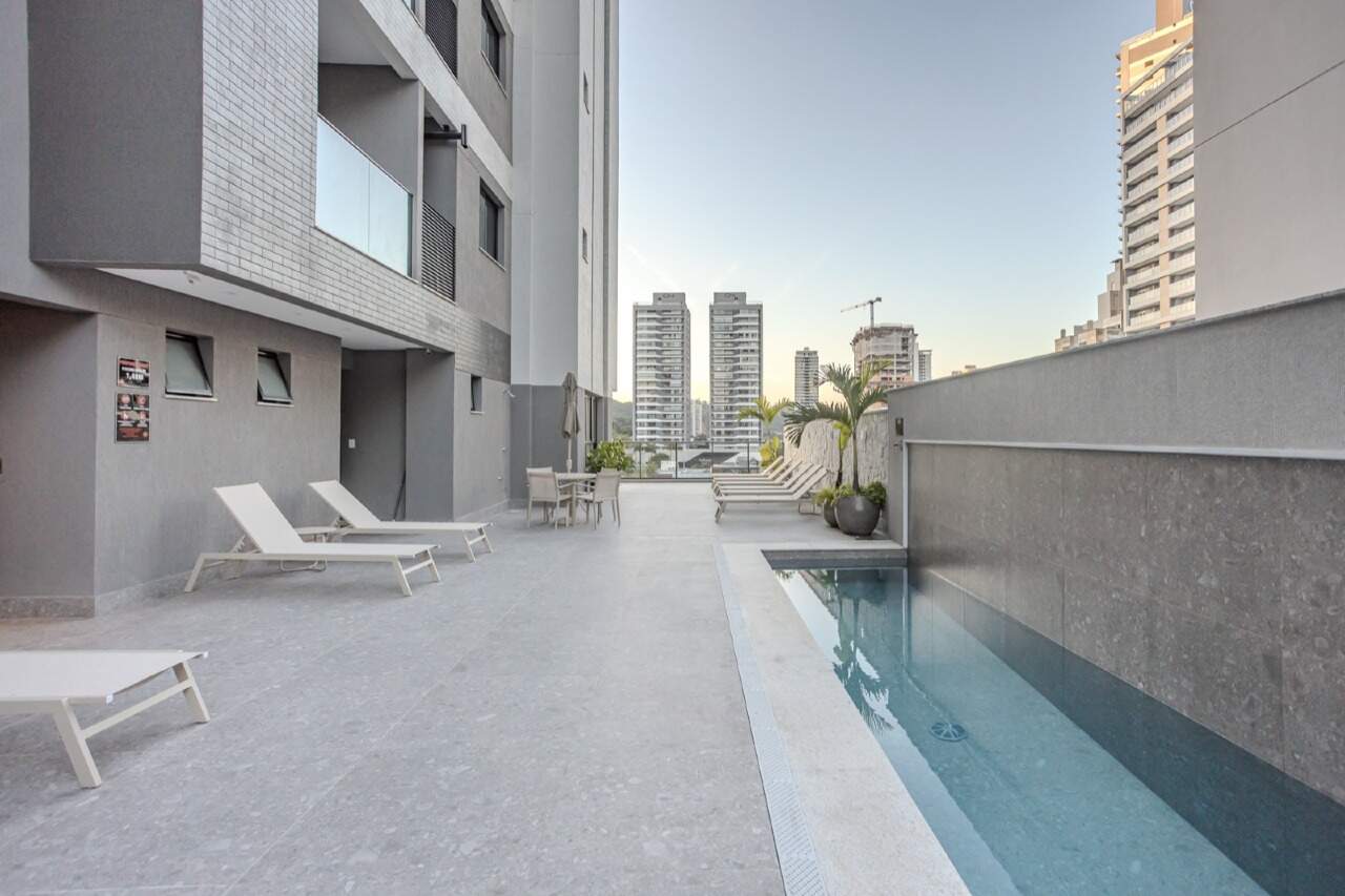 Piscina com raia e deck vistos do fundo do lazer