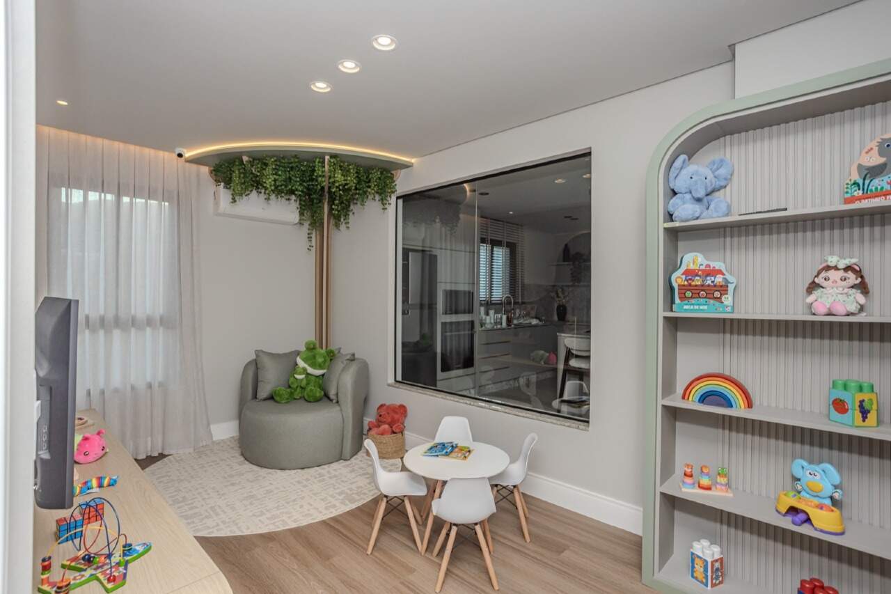 Brinquedoteca com mesinha, estante de brinquedos e árvore decorativa