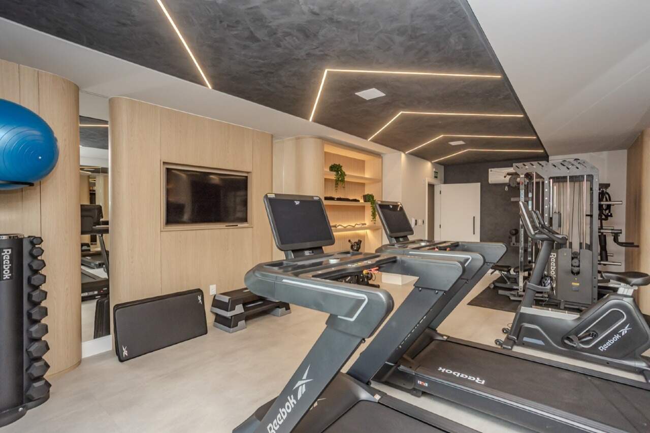 Academia com esteiras, bicicleta e estação de musculação