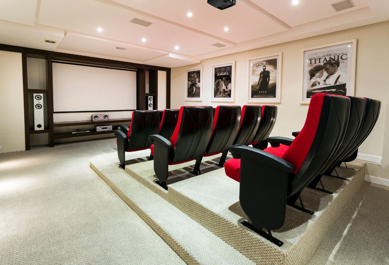 Sala de cinema com tela e poltronas em arquibancada