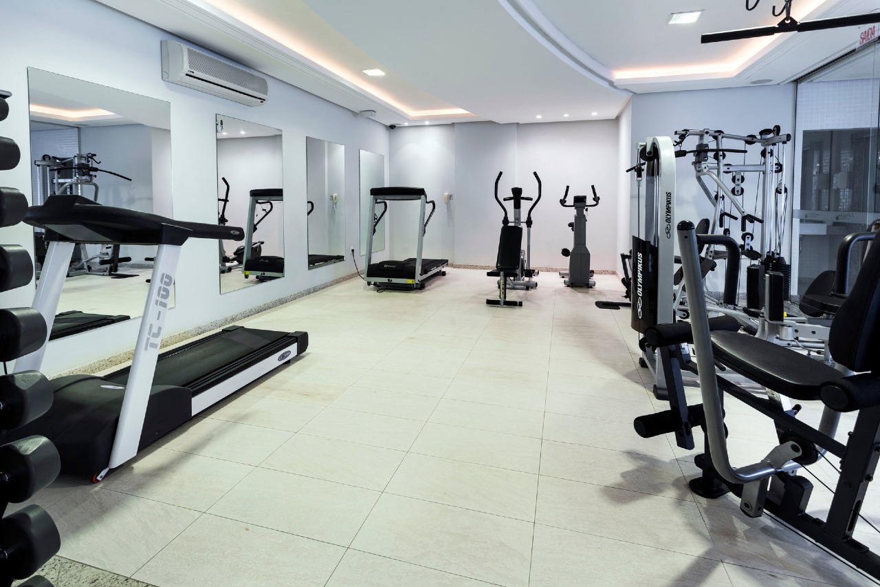 Academia com esteiras, bicicletas e espelhos