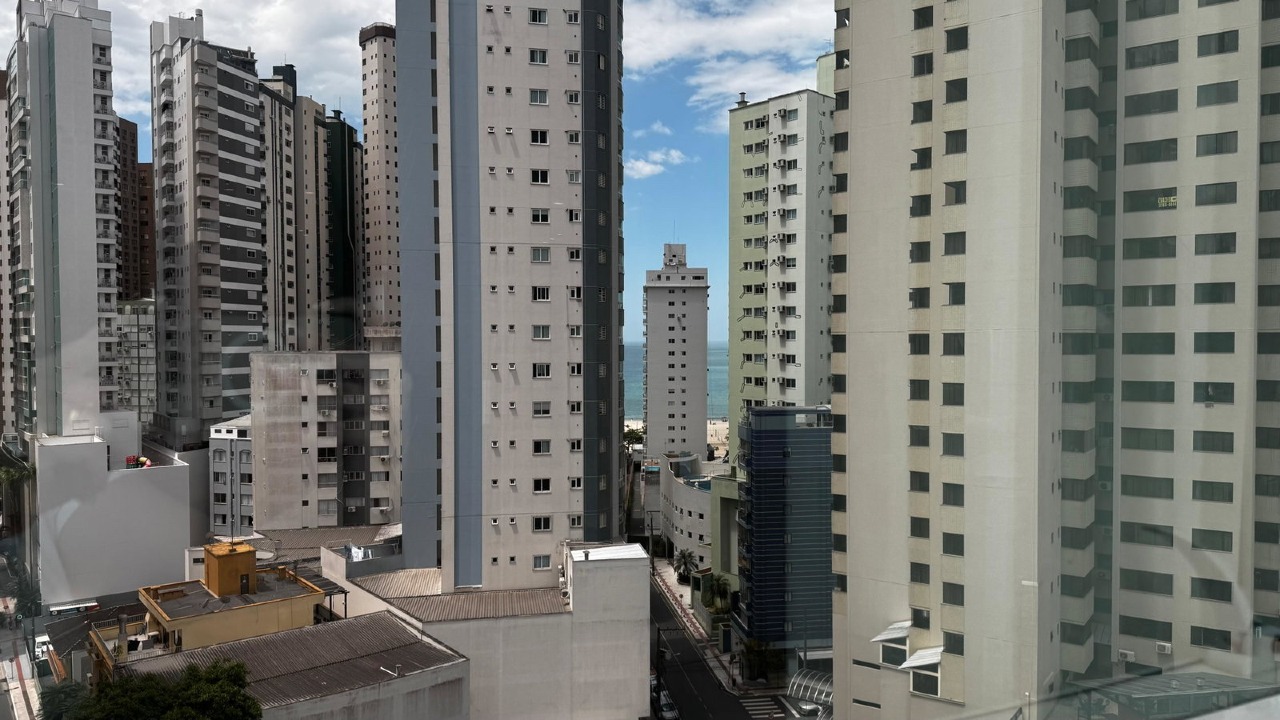 Faixa do mar da Praia Central vista entre os prédios, de um apartamento do prédio