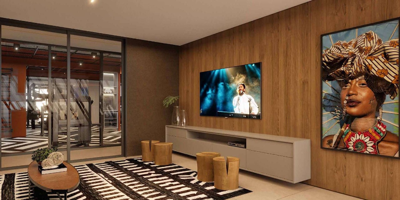 Lounge da área gourmet com arte africana e painel de TV (imagem ilustrativa)
