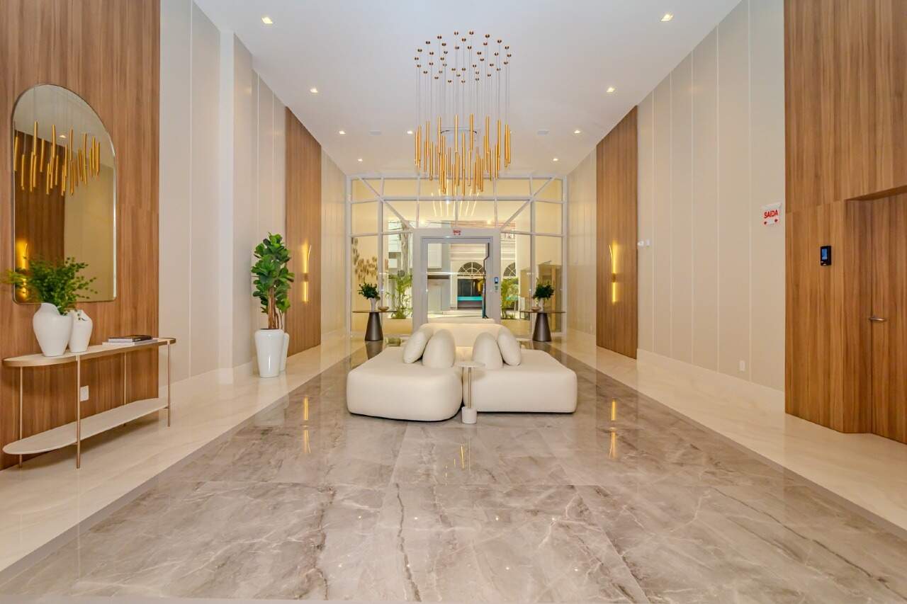 Hall de entrada com estar e passagem para os elevadores