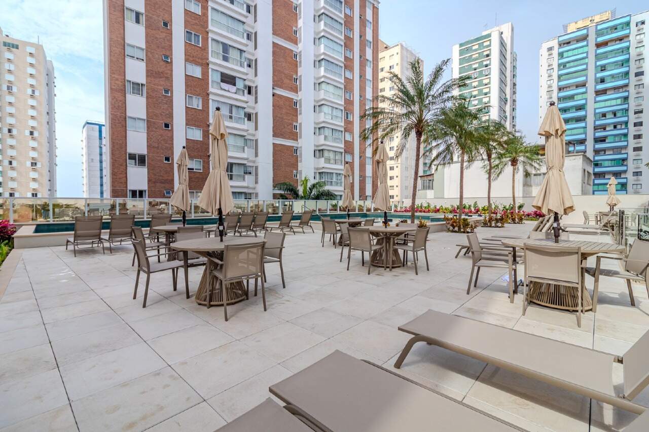 Deck com mesas e espreguiçadeiras junto à piscina