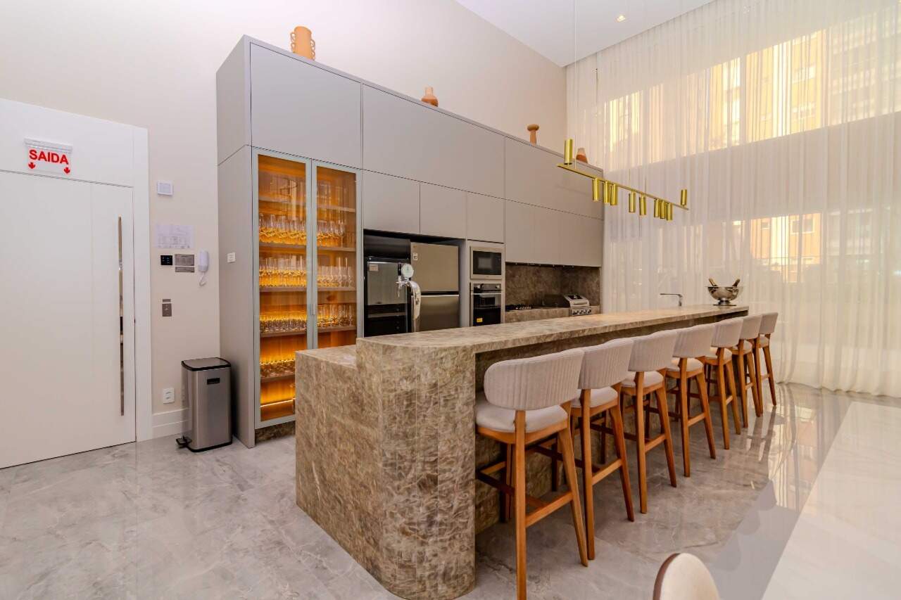 Cozinha do espaço gourmet com bancada, adega e fornos