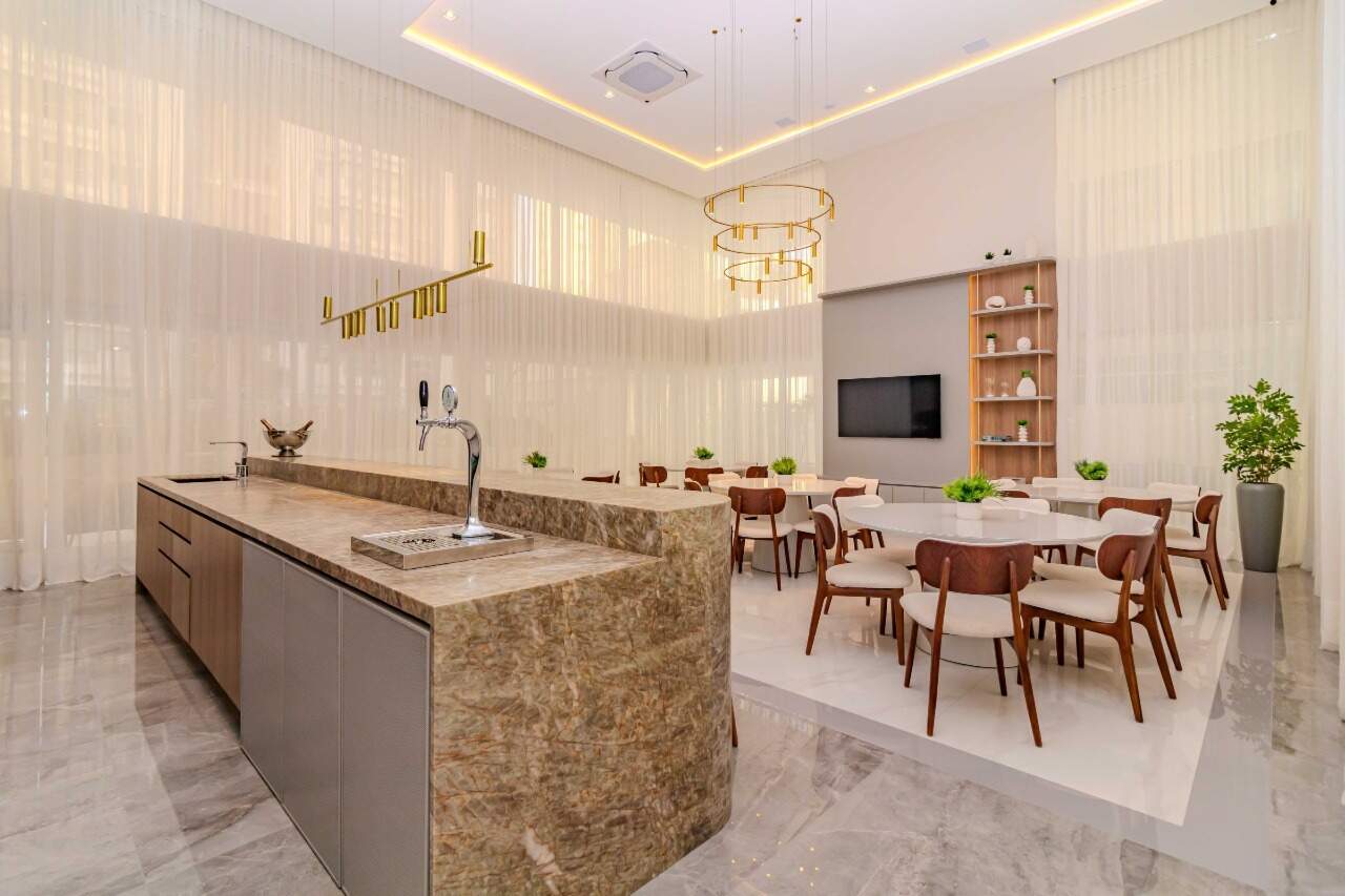 Espaço gourmet com bancada e mesas