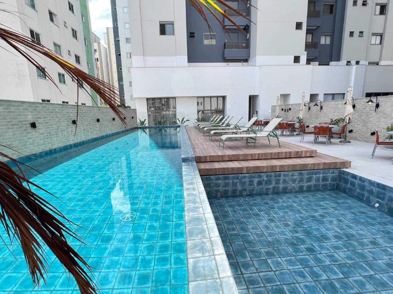 Piscina adulto com deck de madeira e espreguiçadeiras