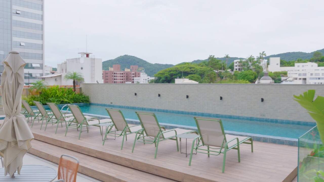 Piscina com espreguiçadeiras e os morros ao fundo