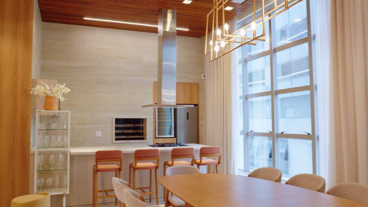 Espaço gourmet com churrasqueira, bancada e mesa comprida