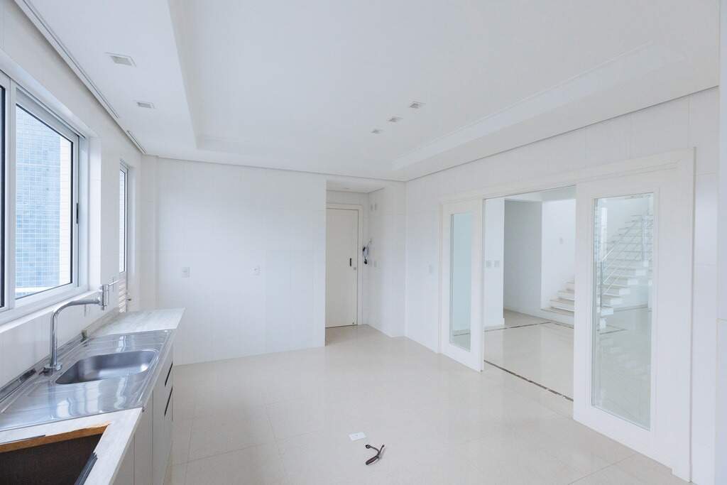 Cozinha com portas de vidro para a sala de jantar, em apartamento tipo