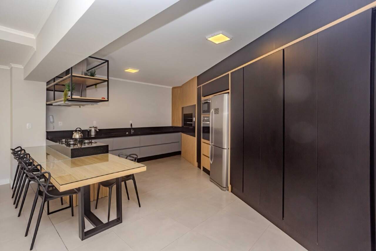 Cozinha do espaço gourmet com cooktop, forno e geladeira
