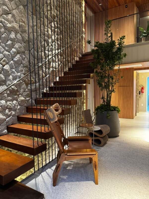 Hall com poltrona de design, jardineira e parede de pedra