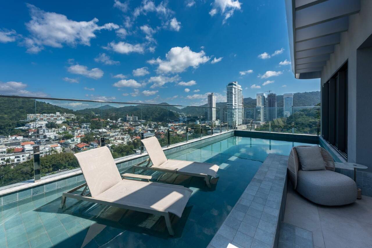 Piscina do rooftop com vista para a Praia Brava e os prédios da região