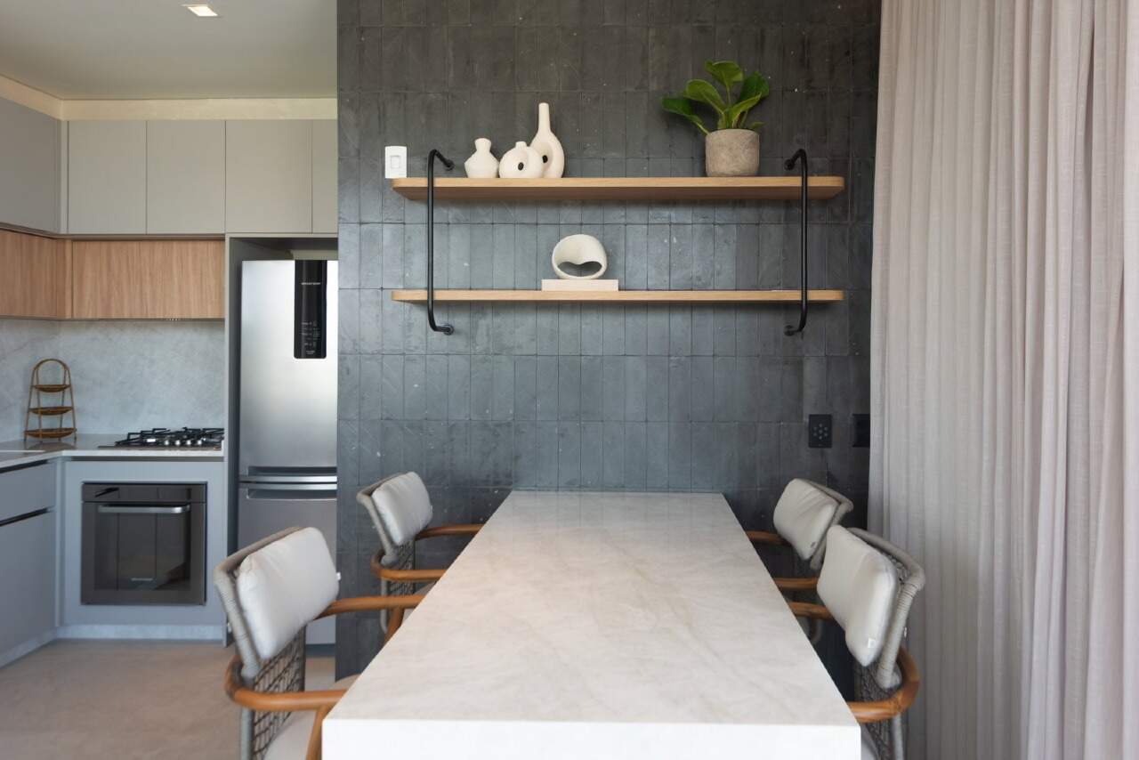 Cozinha do espaço gourmet com mesa de pedra e prateleiras